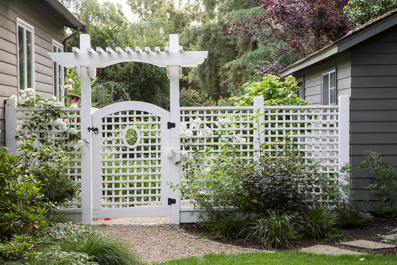 Custom gate with arbor and lattice, with gravel path through garden