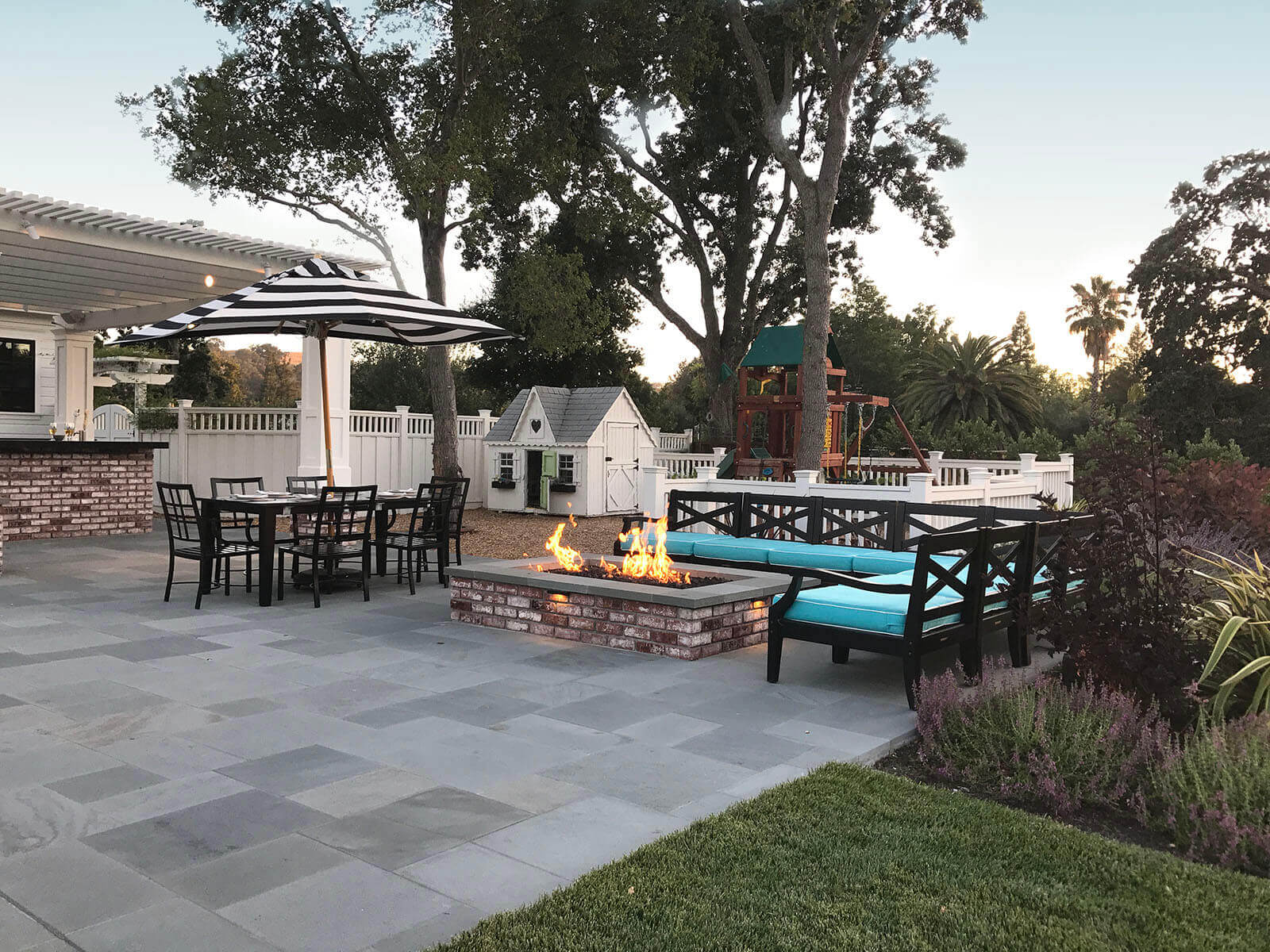 Contemporary bluestone patio with wrap seating surrounding rectangular firepit