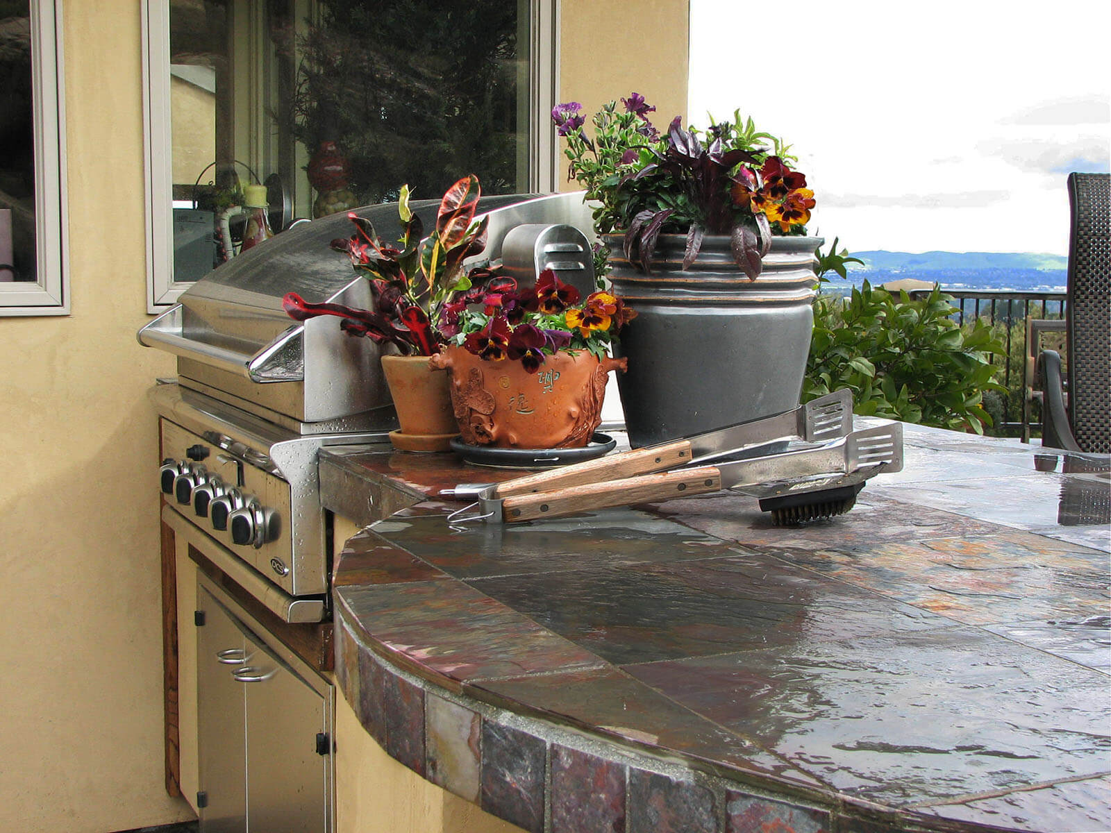 Sealed slate counter tops with flower pots on top and a five burner grill