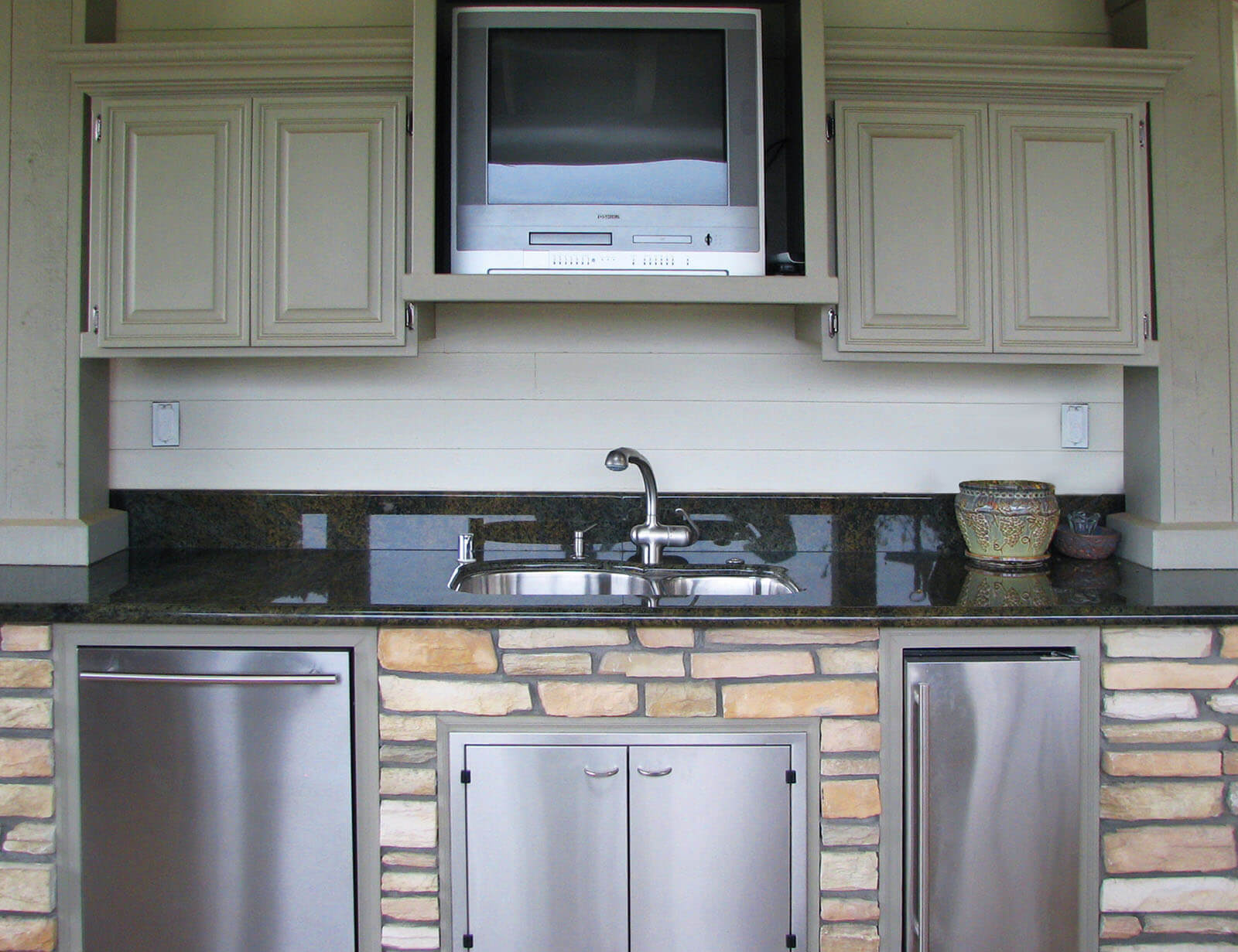 Black stone countertop, partitioned sink, dishwasher, stow space, and mini-fridge