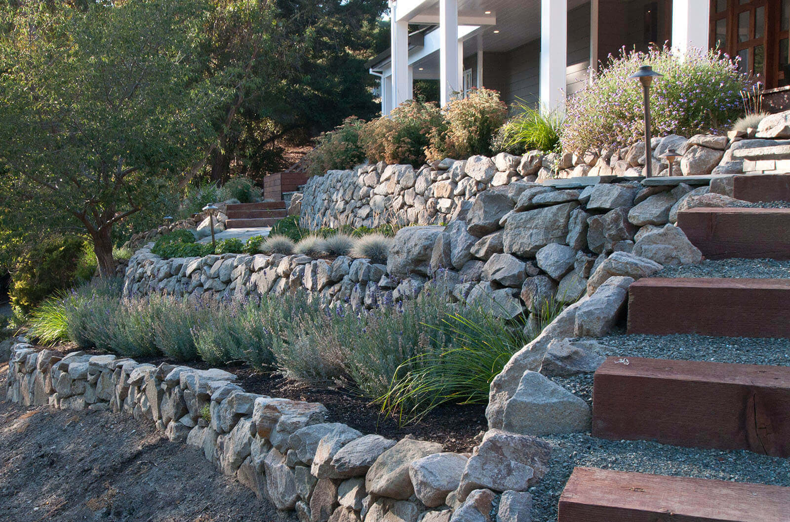 Rock walled staged garden with wood and gravel stairway
