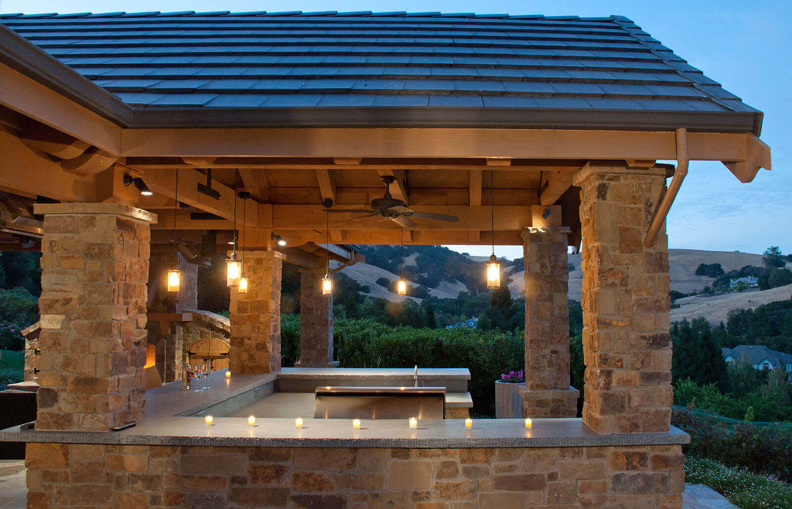 Covered veranda with wrapping counters and hanging lighting fixtures from roof