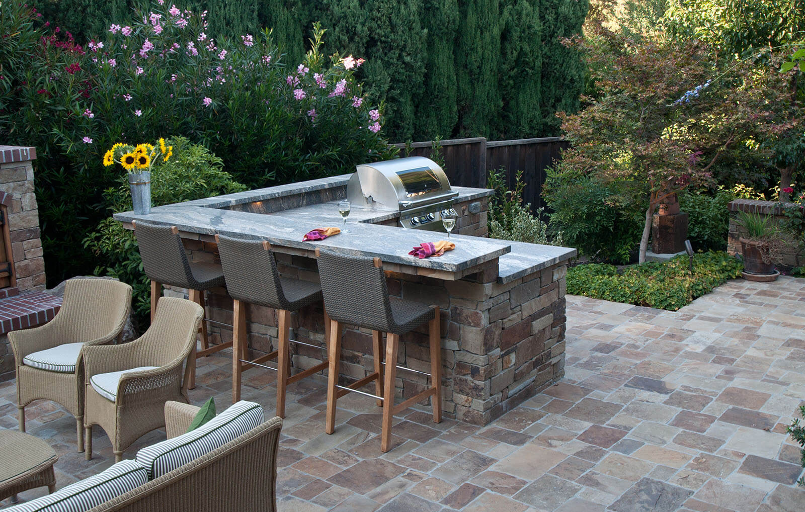 Staged stone counter top and prep area with custom grill, on a stone tile patio