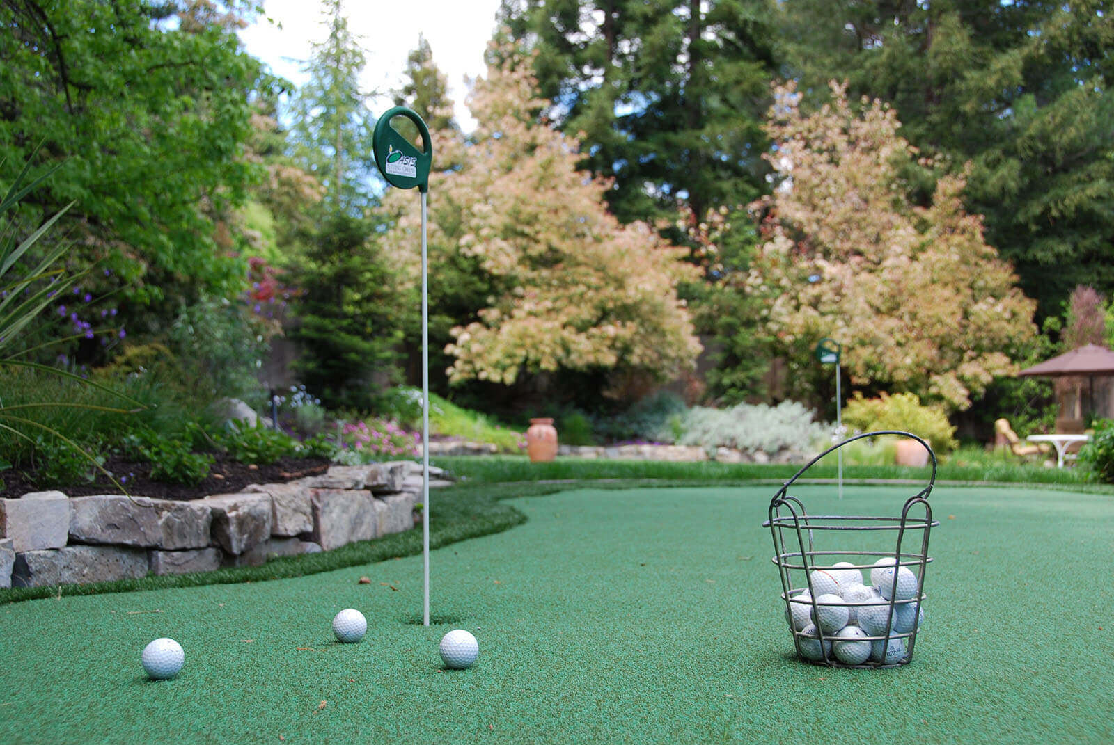 Play - Personal stone-lined putting green, with surrounding short rough zone, complete with two holes
