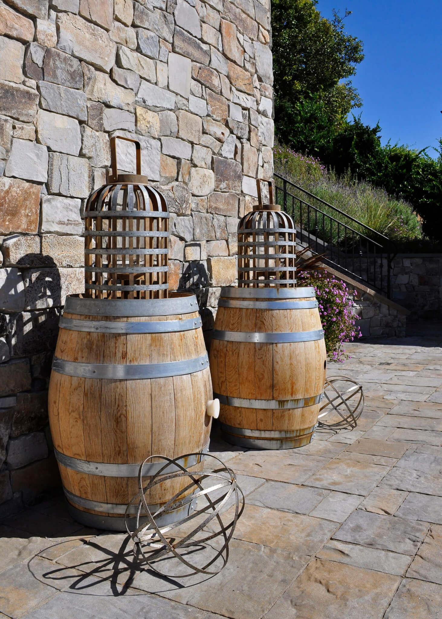 Wooden barrels with rustic cages and stone wall and patio