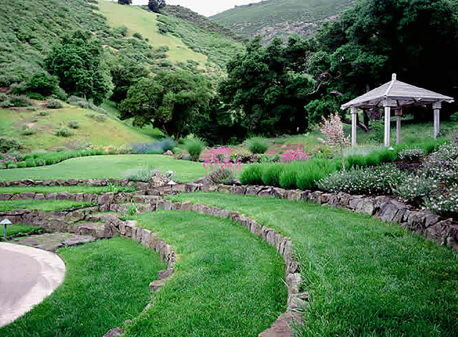 Traditional pavilion with a lush garden and amphitheater-styled lawn set into the hillside landscape