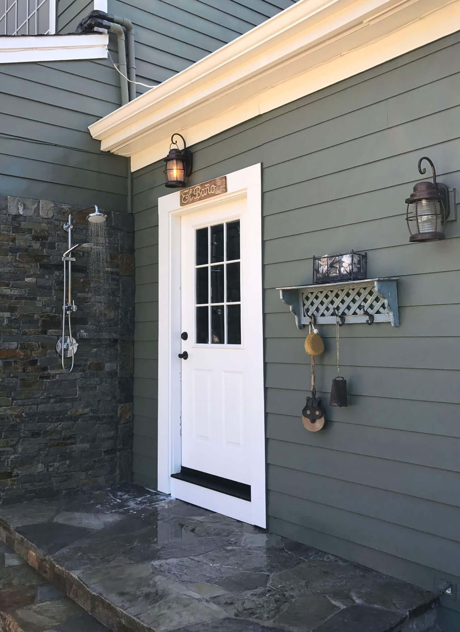 outdoor shower on slate step porch with hanging rack next to the door
