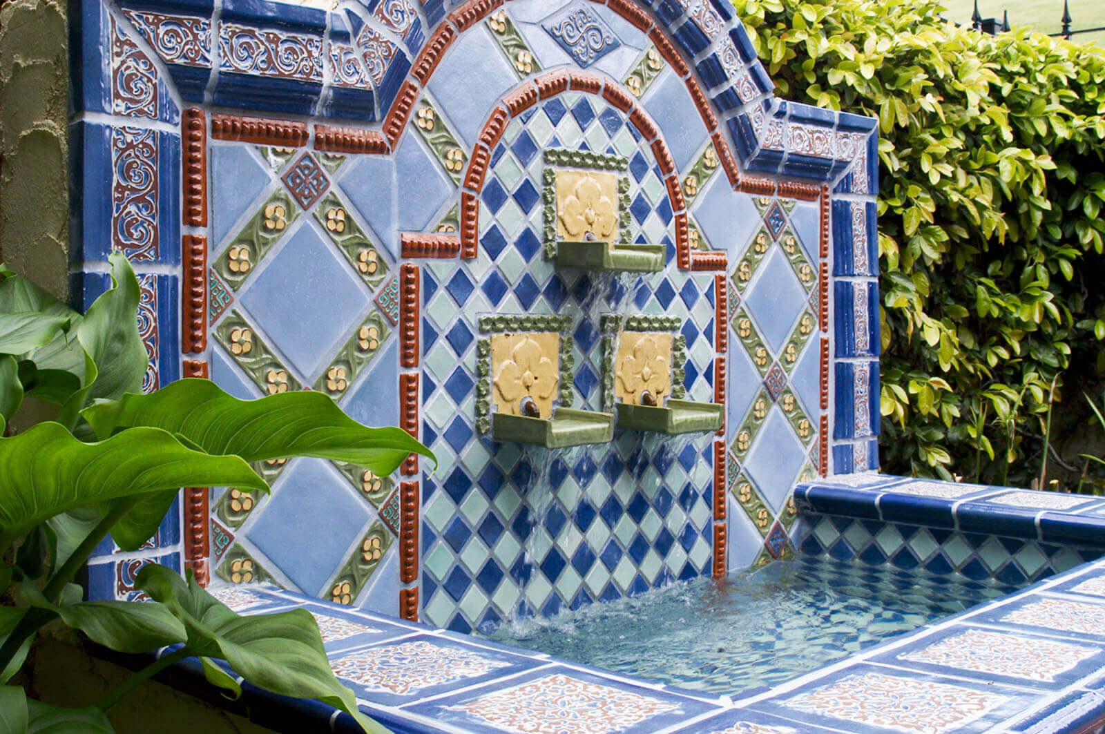 Embellish - Delaplane - Artistic mosaic wall fountain with blue, red, and green tiles, and pool basin