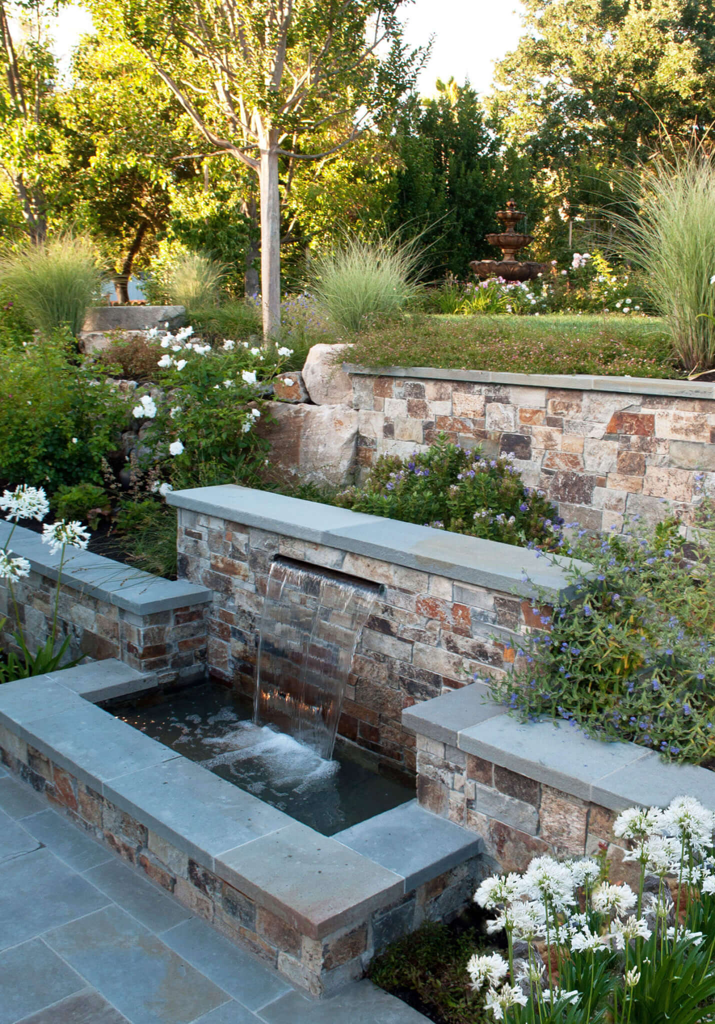 Staged garden with lovely waterfall fountain and tile perimeter