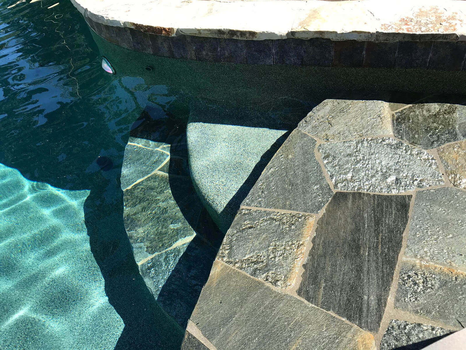 Stone steps lead down into inviting pool