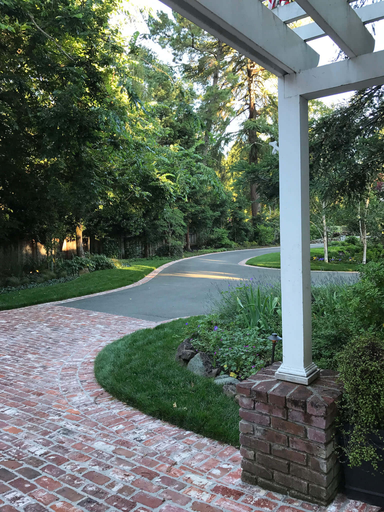 brick-lined driveway leading to brick section under pergola