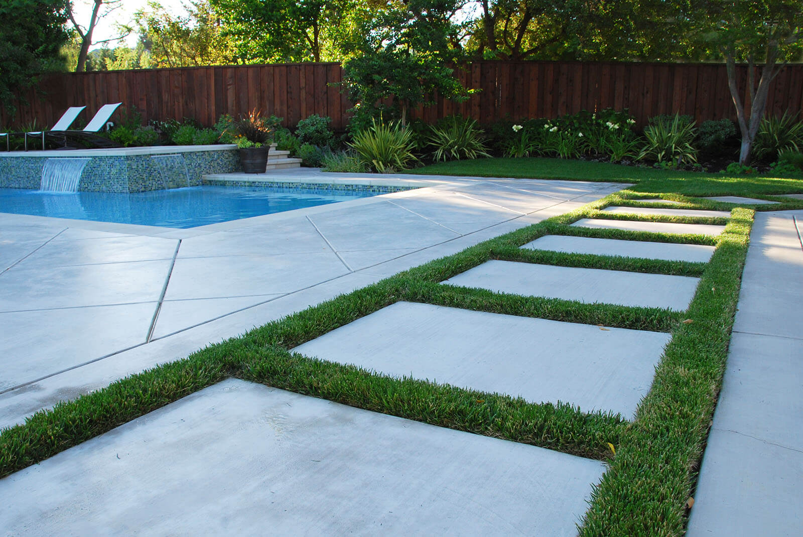 Stone tile on medium grass, with stone tile patio and pool deck