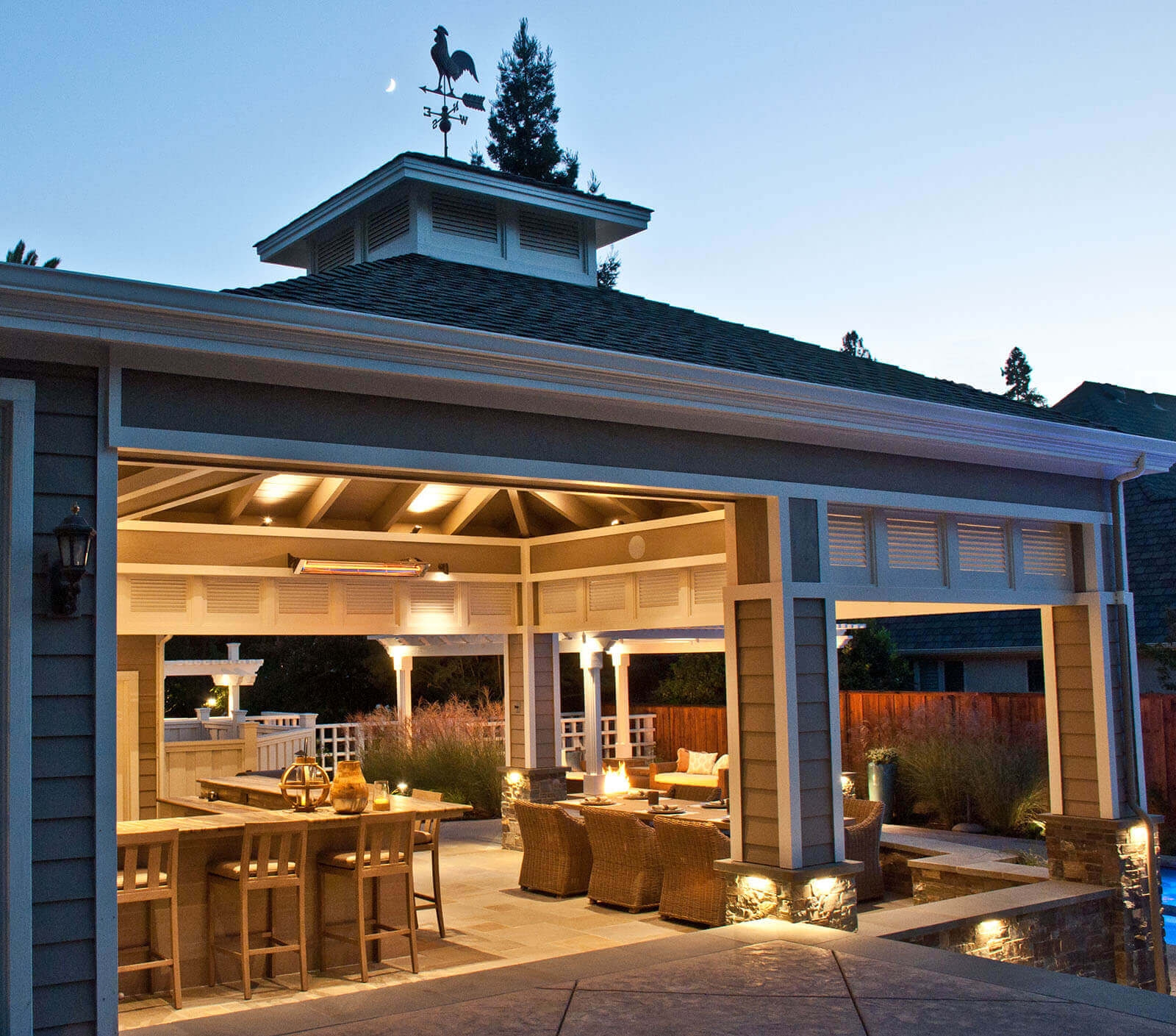 Warm ambient lighting for covered outdoor veranda, with light fixtures at base of columns