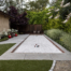 Elegant small bocce court with unique hardscape and lawn geometry and border planting
