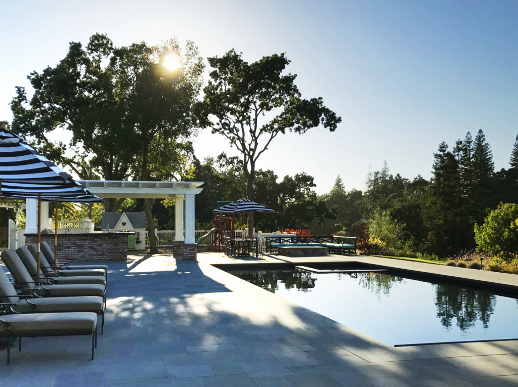 A contemporary pool and spa sits level with the bluestone patio, seamless in the expansive landscape.