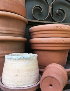 terra cotta pots in different style, one showing a drainage hole