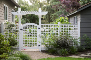 Classical gate with latticework and overhead trellis provides privacy and interest in the garden