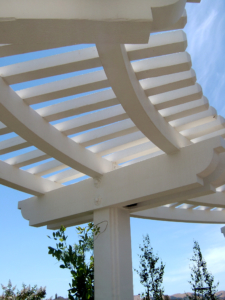 Detail of curved white arbor against blue sky