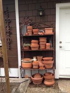 Arranged terra cotta pots on a metal shelf