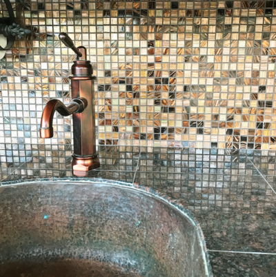 Copper sink with granite countertop and luxe tile backsplash in outdoor kitchen