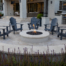 Round fire feature with curved retaining wall and Adirondack chairs on patio