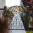 Ornate metal accent gate to side garden with burgundy and silver planting