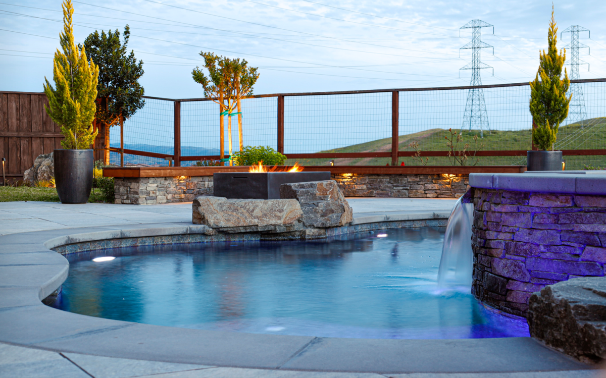 Modern seatwall with inset lighting, hedge behind with landscape uplighting