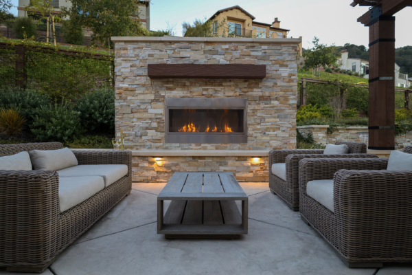 Contemporary outdoor fireplace in stone with wood detailing
